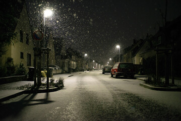 Blurred background. City view, lights, falling snow, night, street, bokeh spots moving cars winter scenery Lantern light