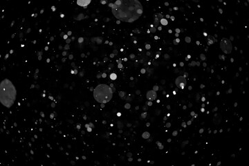  Bokeh lights on black background, shot of flying snowflakes in the air