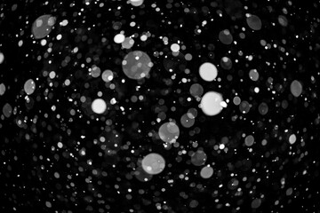  Bokeh lights on black background, shot of flying snowflakes in the air