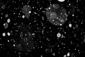  Bokeh lights on black background, shot of flying snowflakes in the air