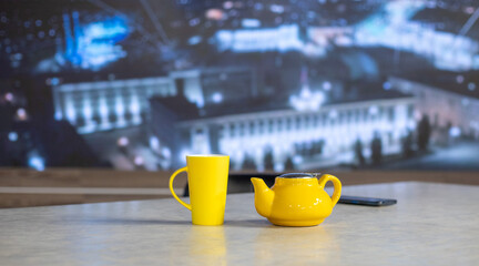 Yellow teapot and glass on a white table. Tea ceremony.