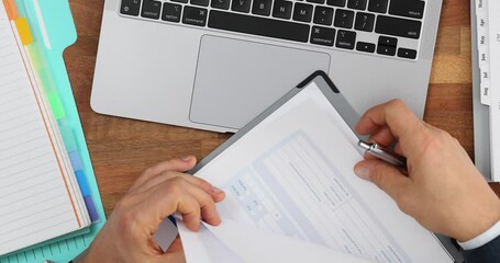 Business employee manually working with stacks of paper files to search and check unfinished archives top view