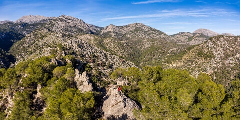 hiker admiring the view of the Tramuntana mountain range from Puig de n'Escuder, Caimari, Mallorca,...