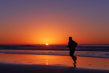Fototapeta na wymiar Sihouette of running man at Scripps Pier, La Jolla, California