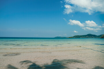 Tropical beach at Koh Kood, Thailand. turquoise sea water, ocean wave, yellow sand, green palms, sun blue sky, white clouds, beautiful seascape, summer holidays, exotic island vacation.