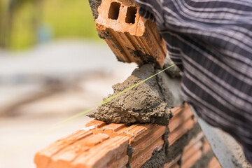 Hand worker masonry brickwork trowel construction site wall concrete background - 720051032