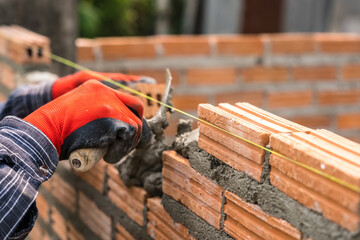 Hand worker masonry brickwork trowel construction site wall concrete background - 720051093