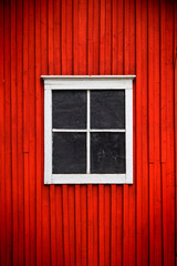 White window on red wooden wall. Traditional Finnish Architecture.