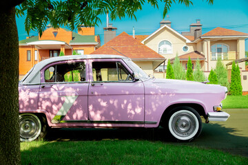 retro car near a private house on the road. Sunset. Bright car. Round headlights. High quality photo