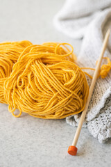 Close up of yellow yarn and knitting needles.