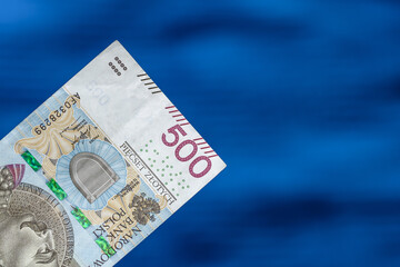 Jeden banknot polski o nominale 500 złotych z bliska na niebieskim rozmytym tle
