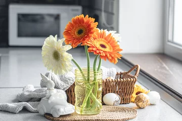 Poster Easter composition with gerbera flowers and eggs in kitchen interior. © puhimec