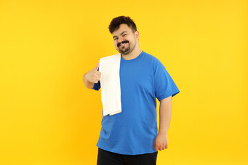 A fat man is tired after training, on a yellow background.