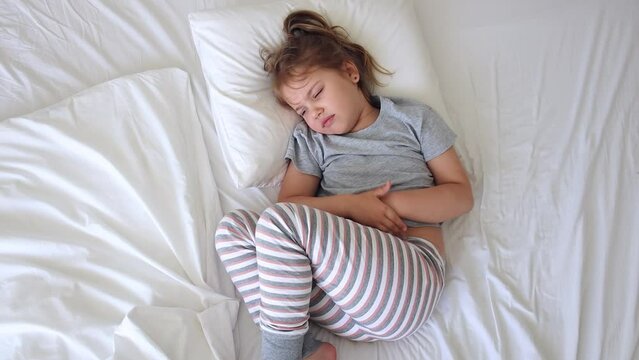 Child with stomach ache.Little girl suffering of belly pain. Caucasian kid health problems.