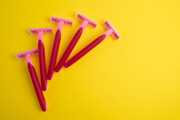 Pink women's razors isolated on yellow and pink background. Pink women's disposable razors. Skin...