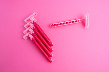 Pink women's razors isolated on yellow and pink background. Pink women's disposable razors. Skin and body care concept. Depilation. Place for text