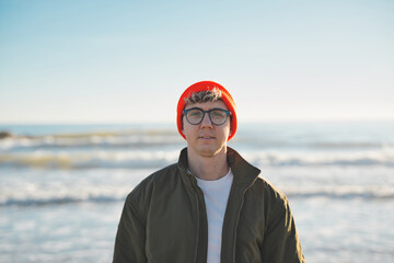 Close up portrait of cheerful attractive young Caucasian man happy smiling face on beach. Male...