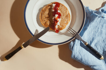 Plant based vegan  strawberry jam and coconut paste whole wheat pancakes top view sunny shot