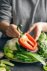 Close-up, cut bell pepper in female hands in the kitchen.