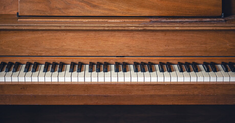 Fototapeta na wymiar Piano keys on wooden brown musical instrument.