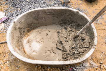 Mix cement sand and stones with hoe leak inside big bucket on floor background - 720101485