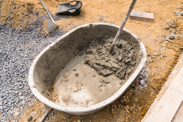 Mix cement sand and stones with hoe leak inside big bucket on floor background - 720101497