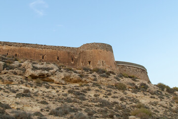 Fototapeta na wymiar Castillo o batería de San Ramón en Rodalquilar, Almería, España. Vista de las paredes de la estructura de defensa costera construida en 1764.