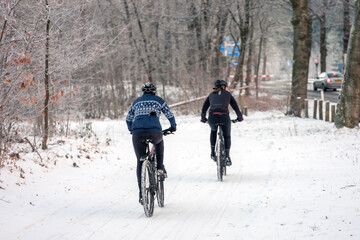 women on mountain bikes in snowy forest near utrecht in the netherlands