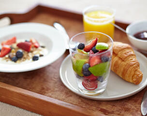 Wellness, food and closeup of breakfast tray with muesli for balance, benefits or gut health. Fruit, zoom and croissant with vitamins for diet, nutrition or healthy eating, brunch or superfoods salad