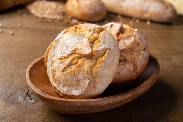 Bakery - Round bread close up. Freshly baked bread with a golden crust on rustic wooden background.