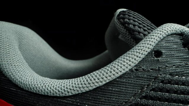 Running shoes made from mesh fabric for better ventilation and lightness. Dolly slider, close up.