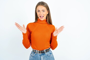 Surprised terrified young beautiful caucasian woman wearing orange turtleneck Gestures with...