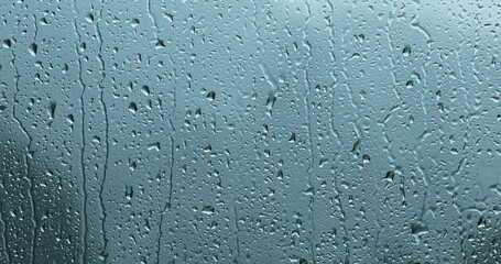 Obraz premium Heavy storm rain droplets pattern on glass window.