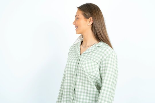 Profile portrait of nice young beautiful woman wearing green plaid pyjama,  look empty space toothy smile