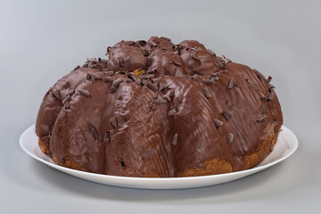 Chocolate panettone with profiteroles on dish on a gray background