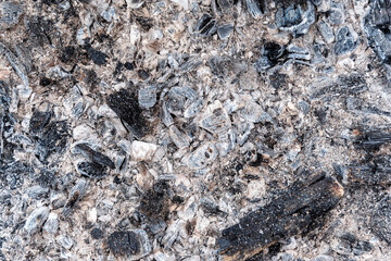 Coal, ash and cinders on a flat surface, all that is left of firewood. For use as an abstract background and texture.