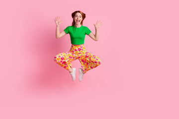 Full size photo of funny childish girl wear stylish top print pants flying in frog pose showing palms isolated on pink color background