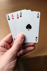Playing cards in hand isolated on a gold background