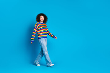 Full body photo of attractive young woman walking model wear trendy rainbow print clothes isolated on blue color background