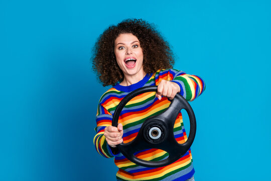 Photo portrait of lovely young lady excited amazed driving dressed stylish rainbow print garment isolated on blue color background