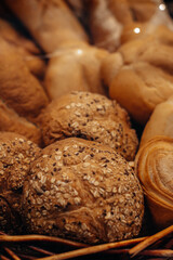 Fresh baked multigrain bread in a wicker basket in a baked goods store. Vertical shot