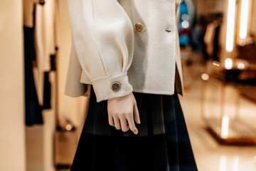 Fancy details of a classic white jacket with golden buttons and black skirt. Women's fashion...