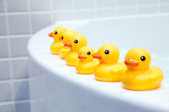 yellow rubber duck on top of a white bathtub