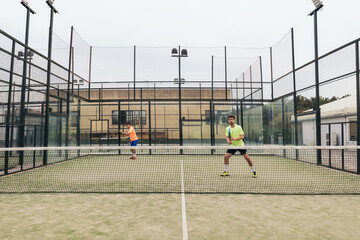 two young man playing paddle tennis