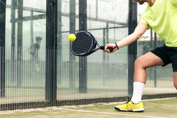 young man playing paddle tennis. close-up - obrazy, fototapety, plakaty