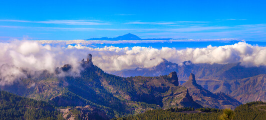 Grand Canary island, panoramic view of Roque nublo over clouds and view of Theide volcano in Tenerife. Canaries islands of Spain - 720210815