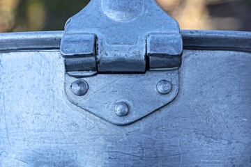 one gray aluminum latch with rivets on a old bowler