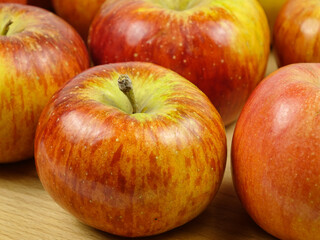 Fresh red-yellow apples are on a board, healthy and organic food, background