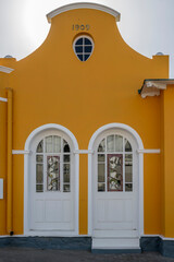 entrance doors of picturesque old mellow yellow building at historical town, Luderitz,  Namibia