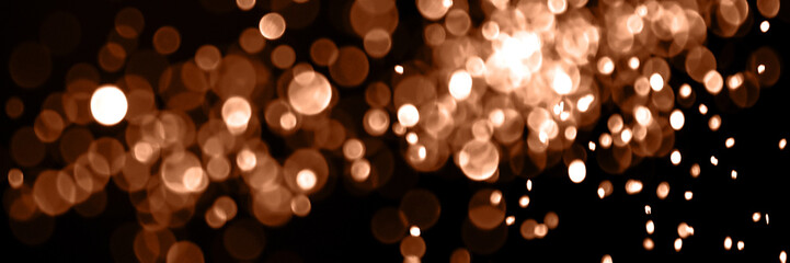 Blurry garland lights on a dark background. Festive Christmas and New Year background. Soft focus....
